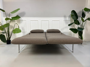 Gebrauchtes braunes Brühl Roro Designer Stoff Sofa vor einer Wand, stilvoll und modern eingerichtet.