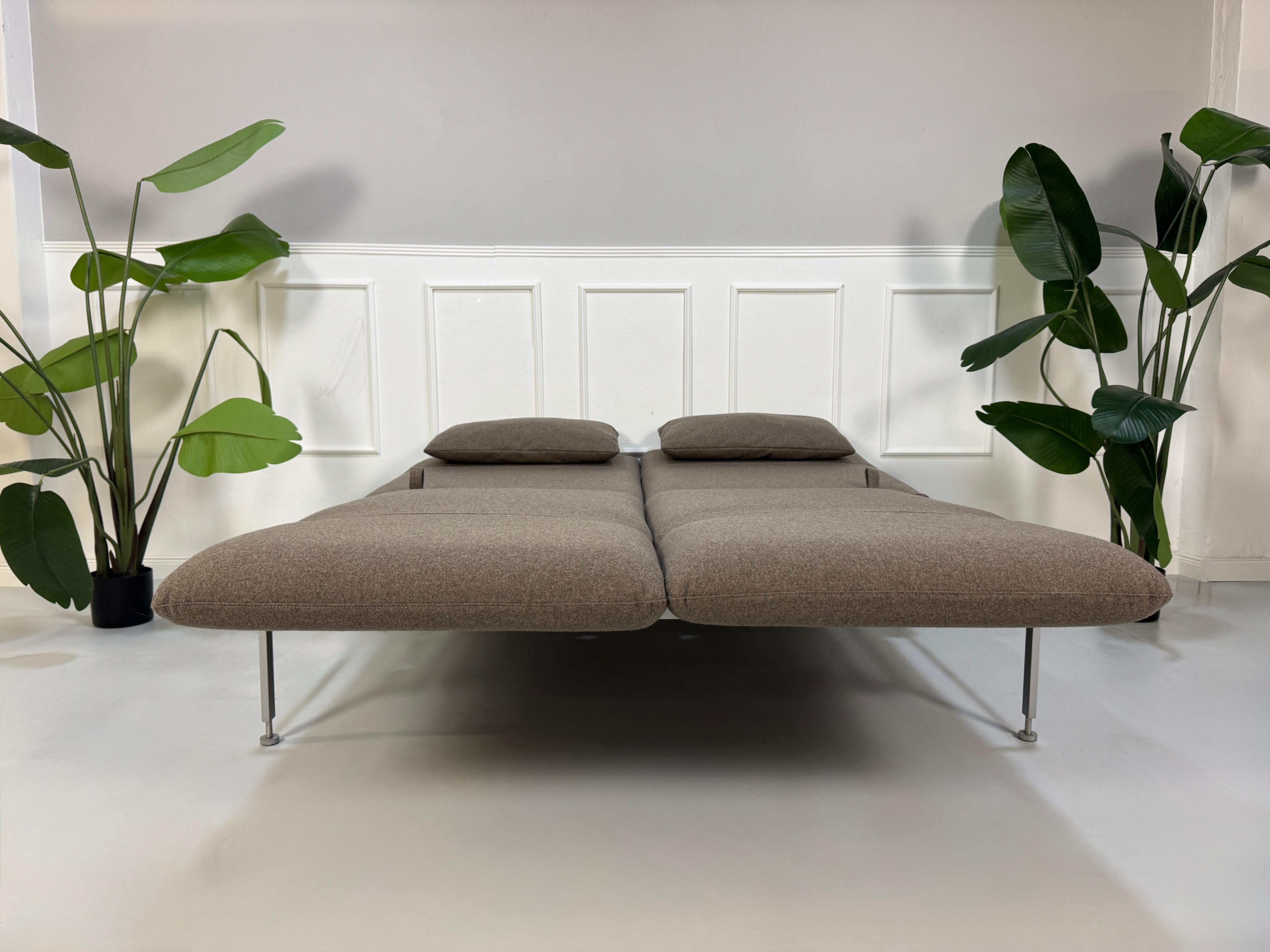 Gebrauchtes braunes Brühl Roro Designer Stoff Sofa vor einer Wand, stilvoll und modern eingerichtet.