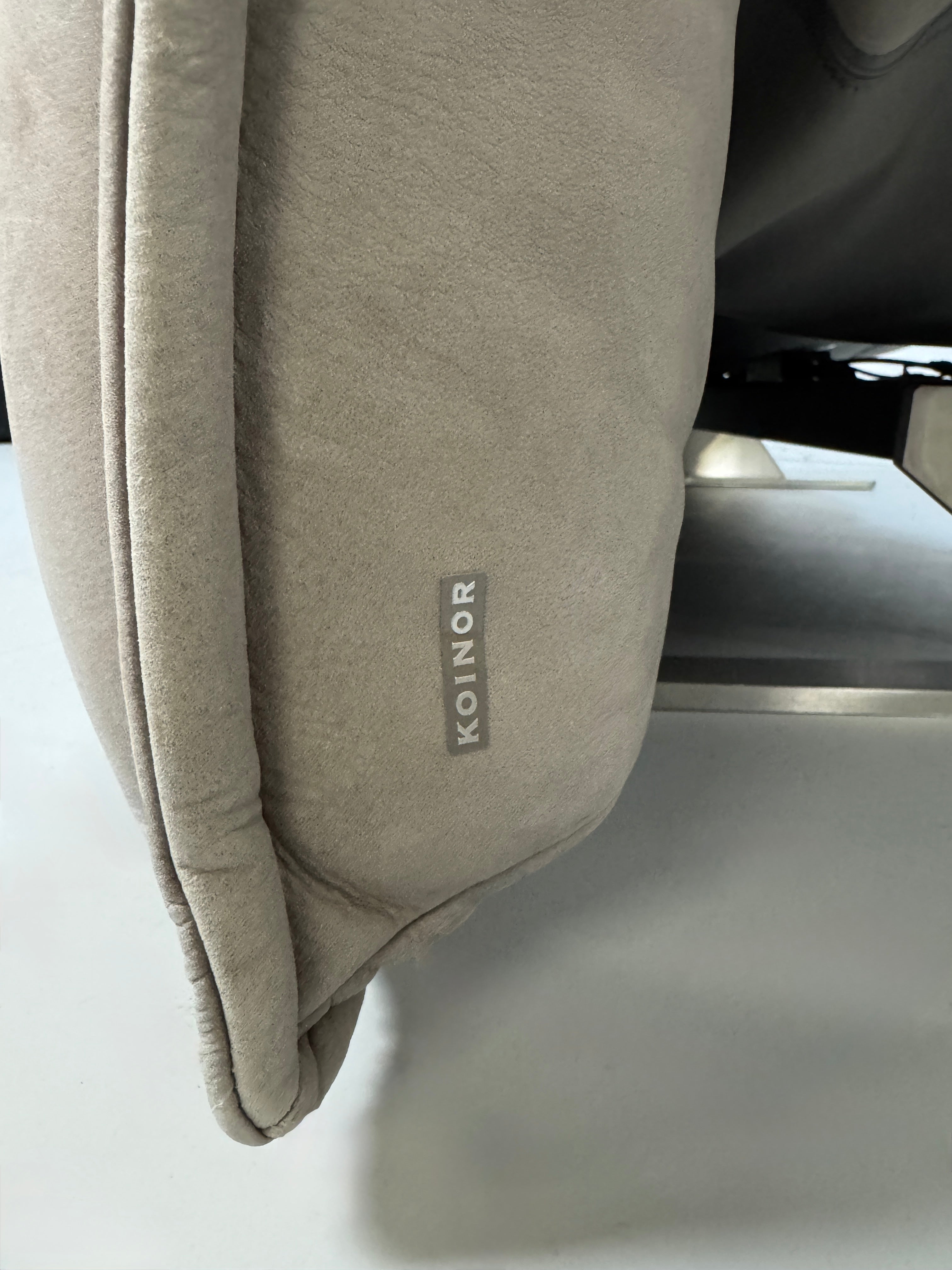 Gebrauchtes graues Ledersofa Koinor Modell Evia vor einer modernen Wand.
