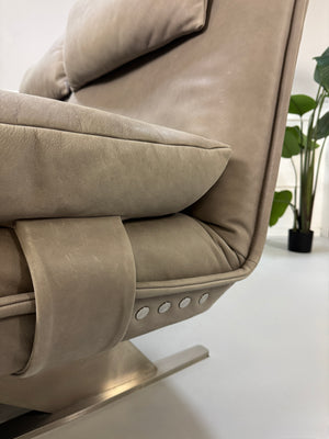 Gebrauchtes graues Ledersofa Koinor Modell Evia vor einer modernen Wand.