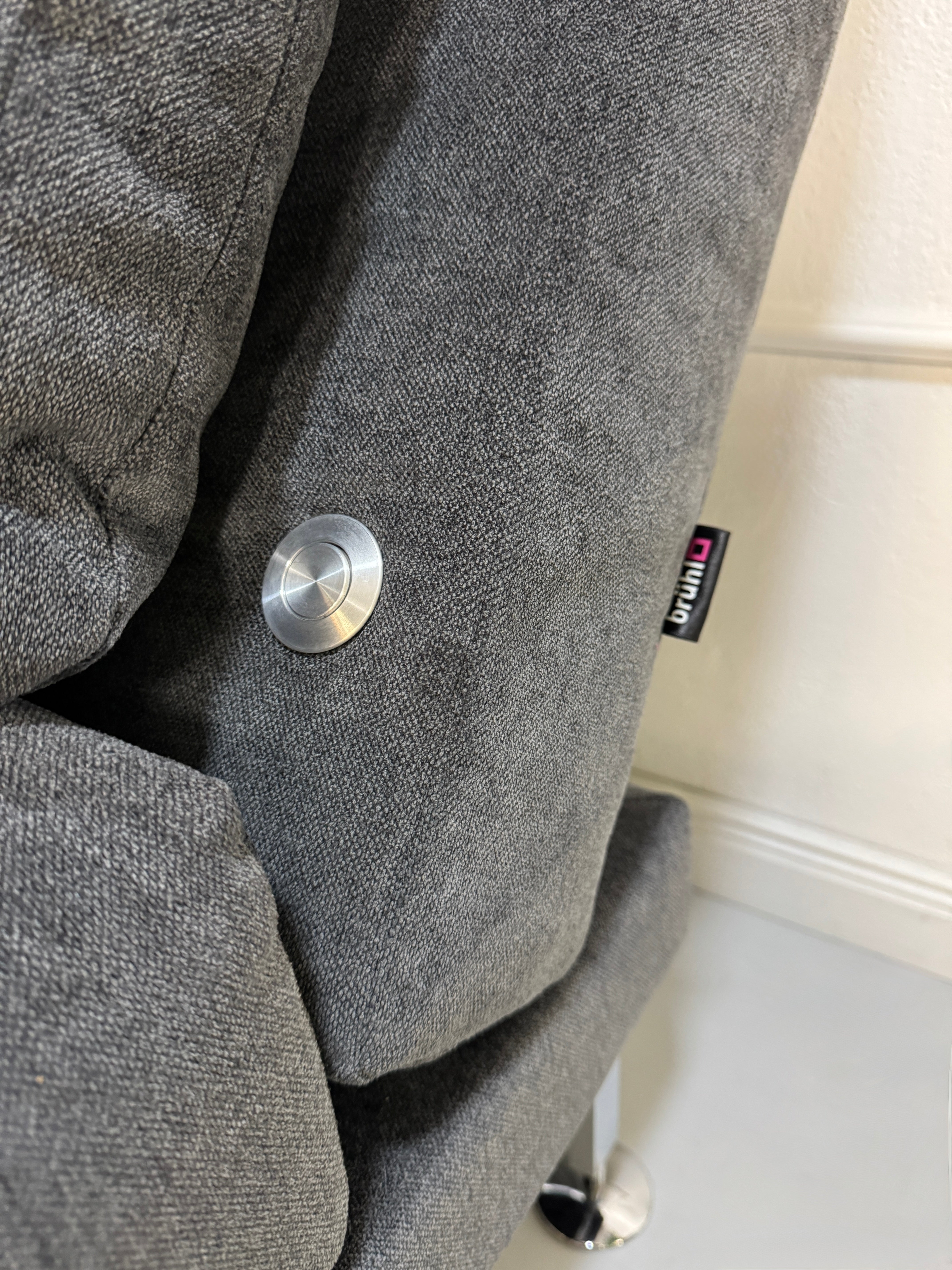 Gebrauchtes graues Stoffsofa Brühl Modell Moule Small vor einer modernen Wand