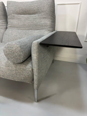 Gebrauchtes graues Stoffsofa mit einem Hocker von COR Modell Avalanche vor einer modernen Wand.