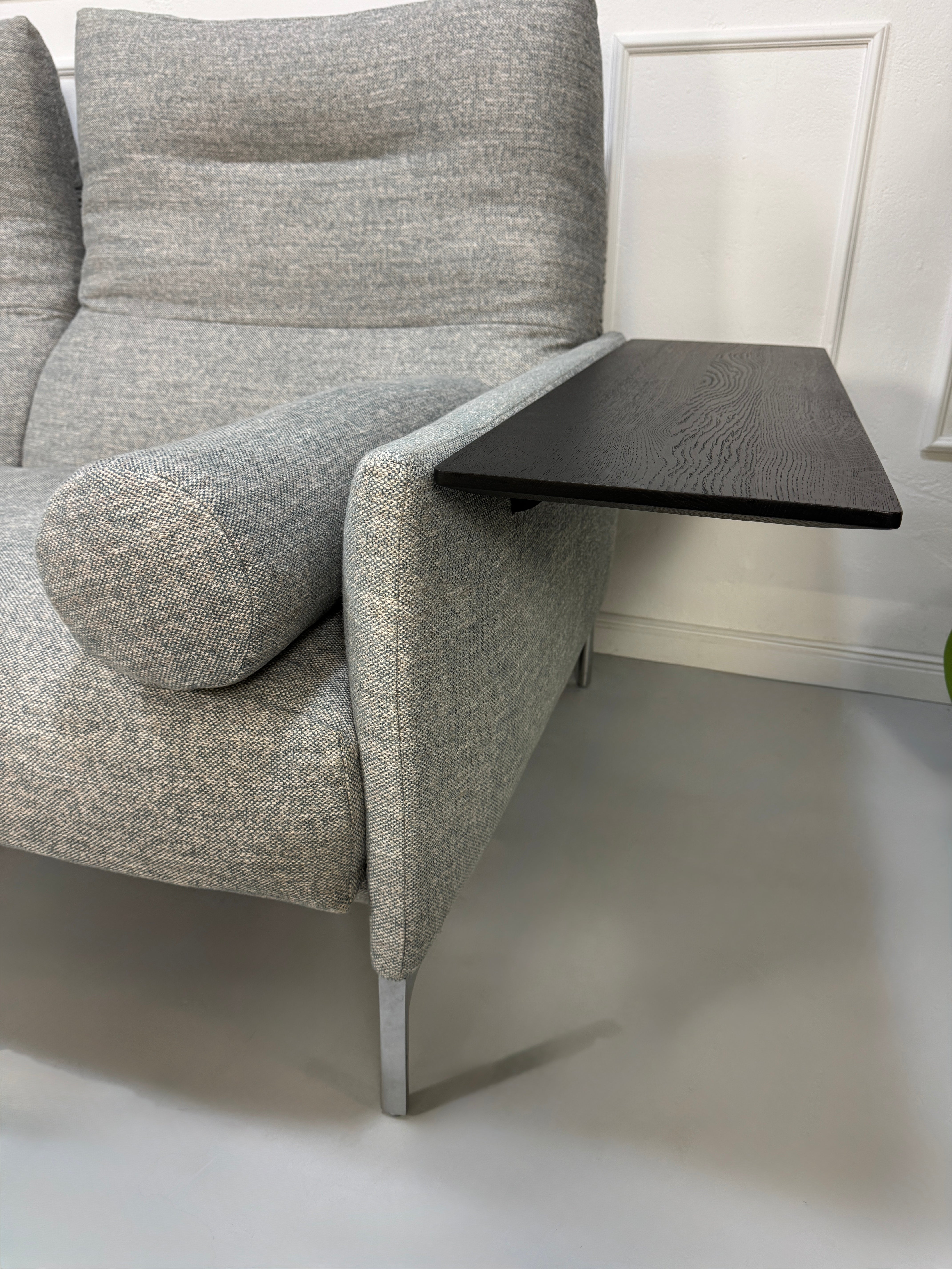 Gebrauchtes graues Stoffsofa mit einem Hocker von COR Modell Avalanche vor einer modernen Wand.