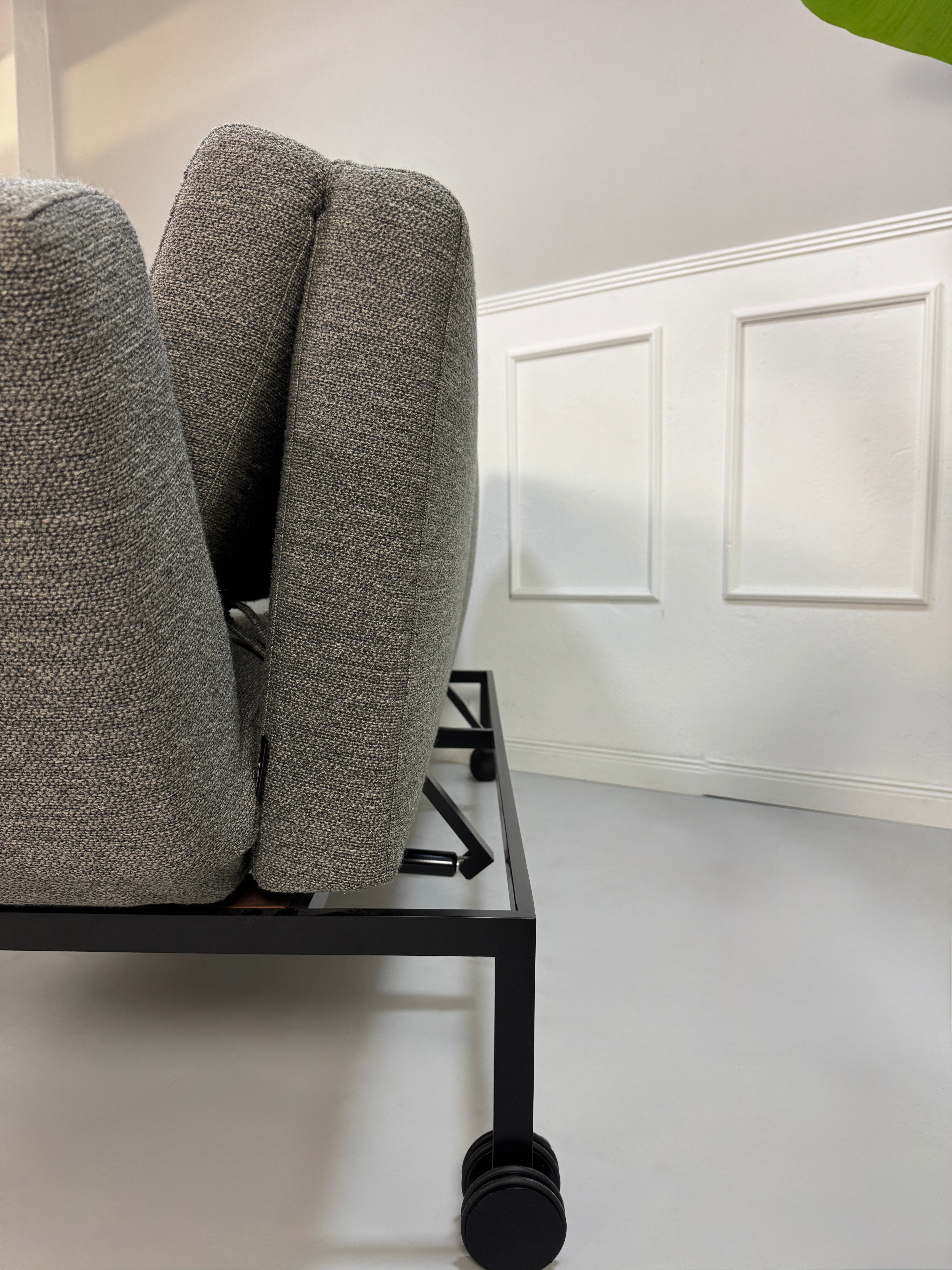 Gebrauchtes graues Stoffsofa Brühl Modell Roro Soft vor einer modernen Wand.