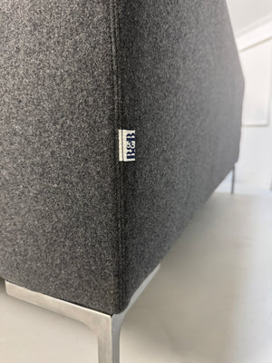 Gebrauchtes graues Stoffsofa  B&B Italia Modell Charles vor einer modernen Wand
