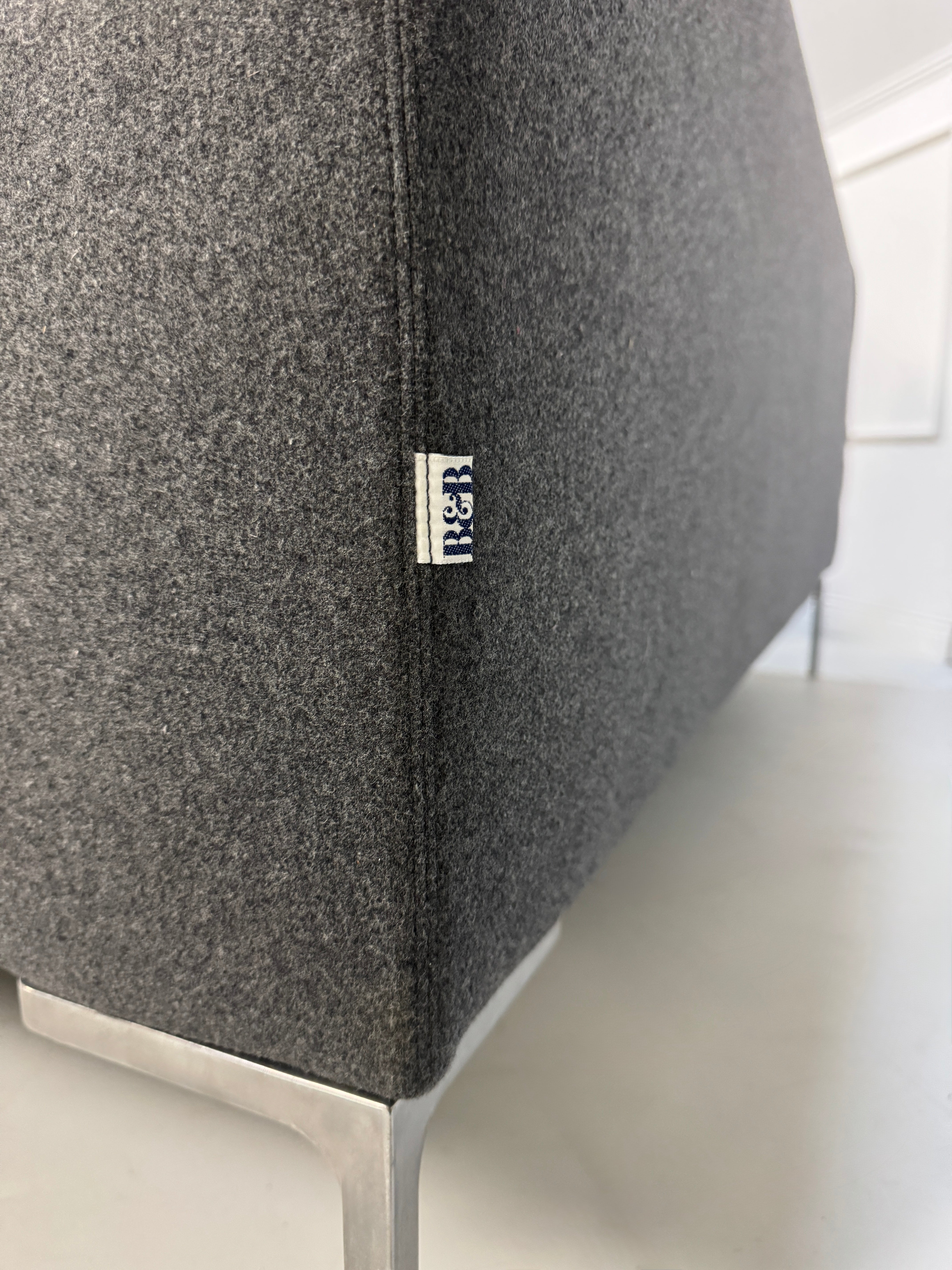 Gebrauchtes graues Stoffsofa  B&B Italia Modell Charles vor einer modernen Wand