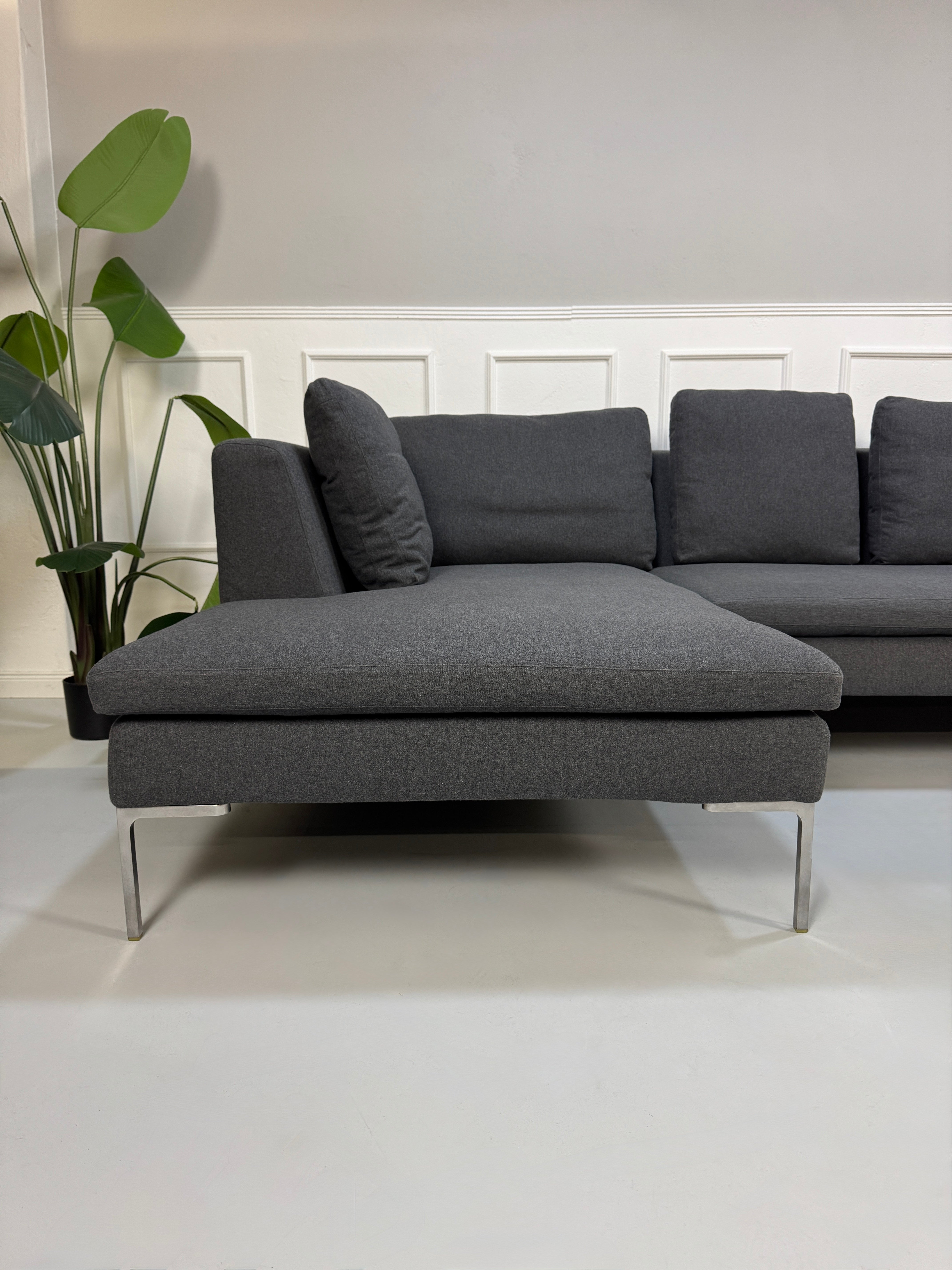 Gebrauchtes graues Stoffsofa  B&B Italia Modell Charles vor einer modernen Wand