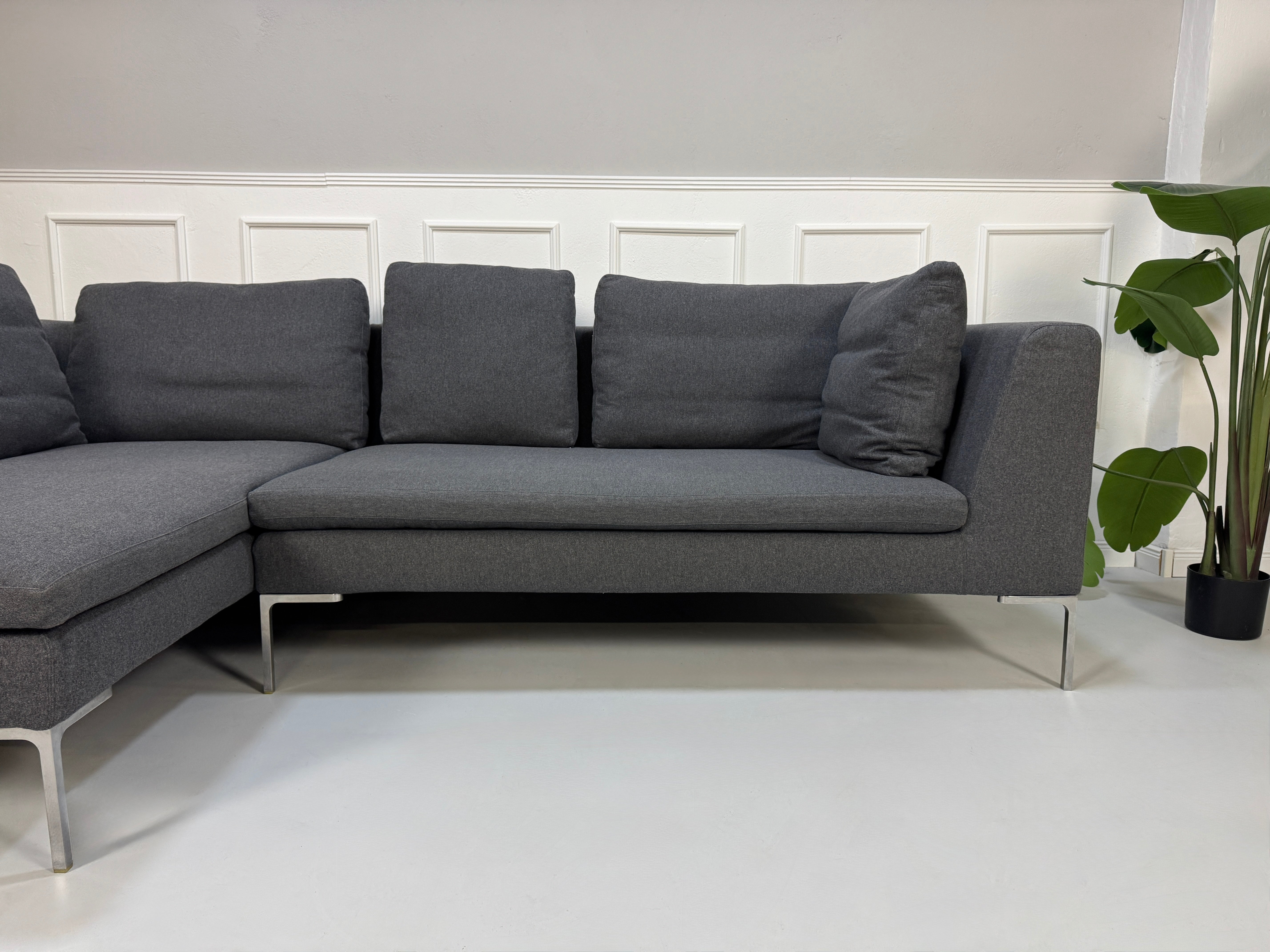 Gebrauchtes graues Stoffsofa  B&B Italia Modell Charles vor einer modernen Wand