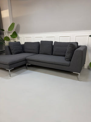 Gebrauchtes graues Stoffsofa  B&B Italia Modell Charles vor einer modernen Wand