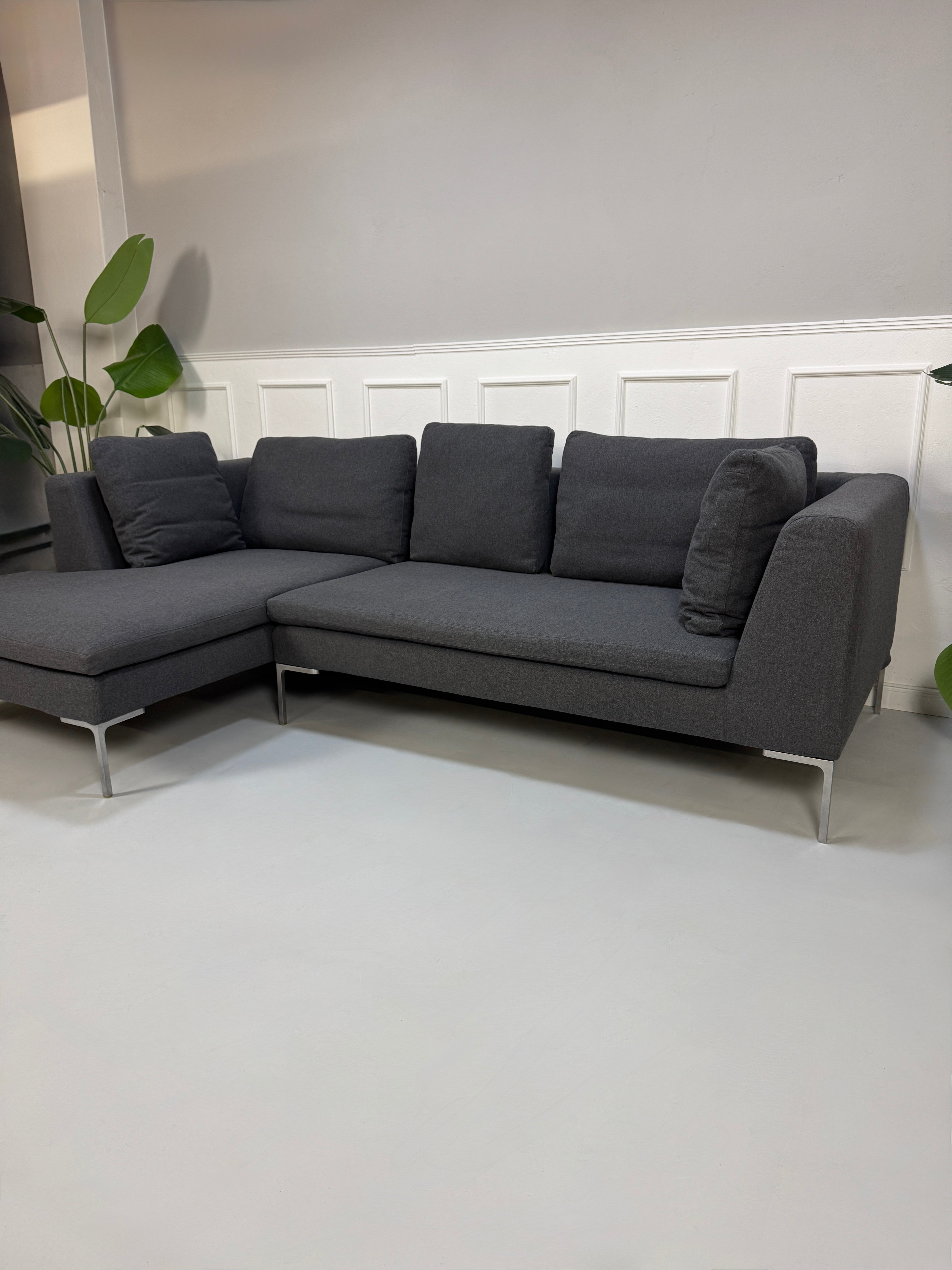 Gebrauchtes graues Stoffsofa  B&B Italia Modell Charles vor einer modernen Wand