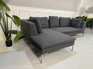 Gebrauchtes graues Stoffsofa  B&B Italia Modell Charles vor einer modernen Wand