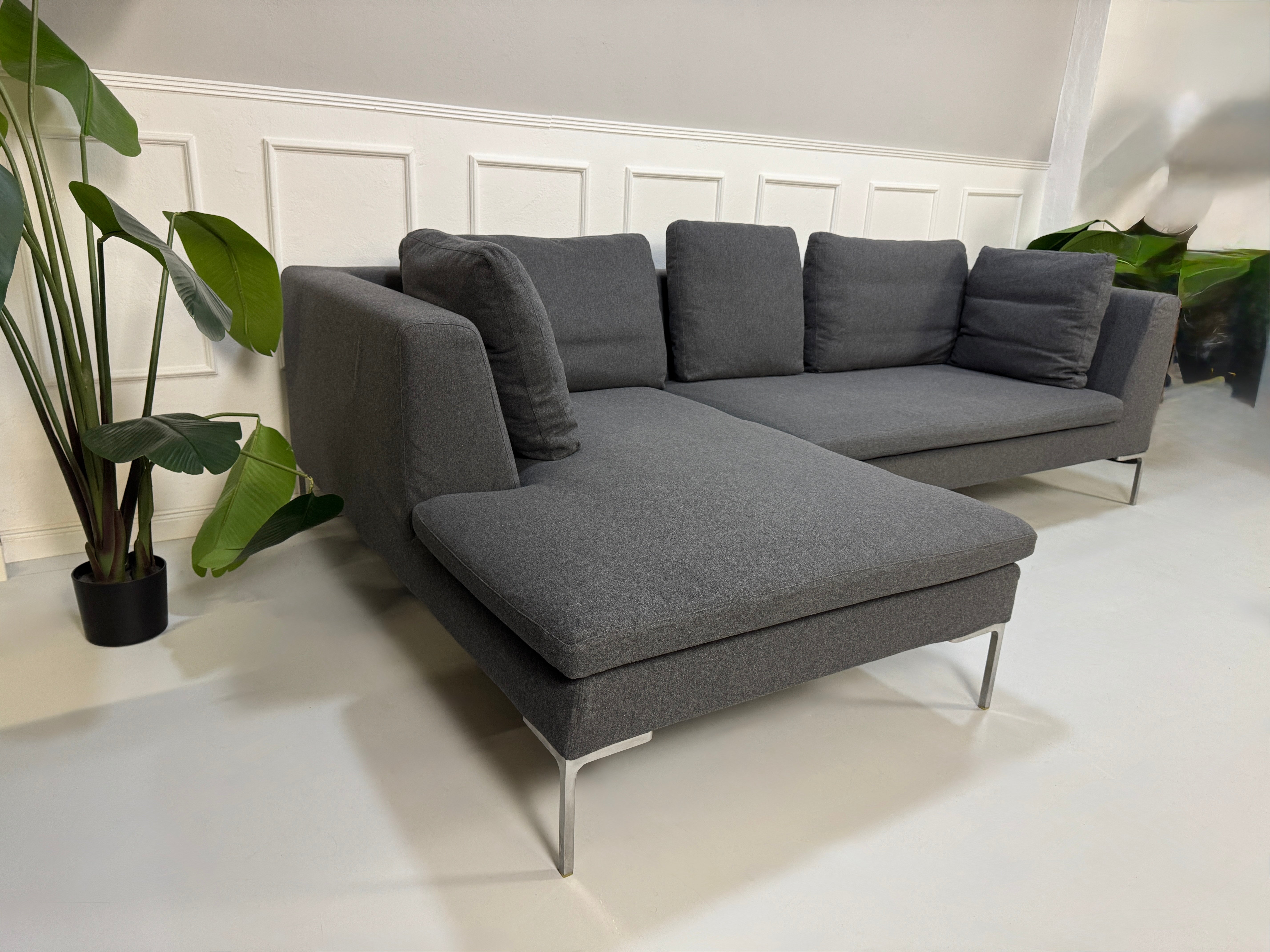 Gebrauchtes graues Stoffsofa  B&B Italia Modell Charles vor einer modernen Wand