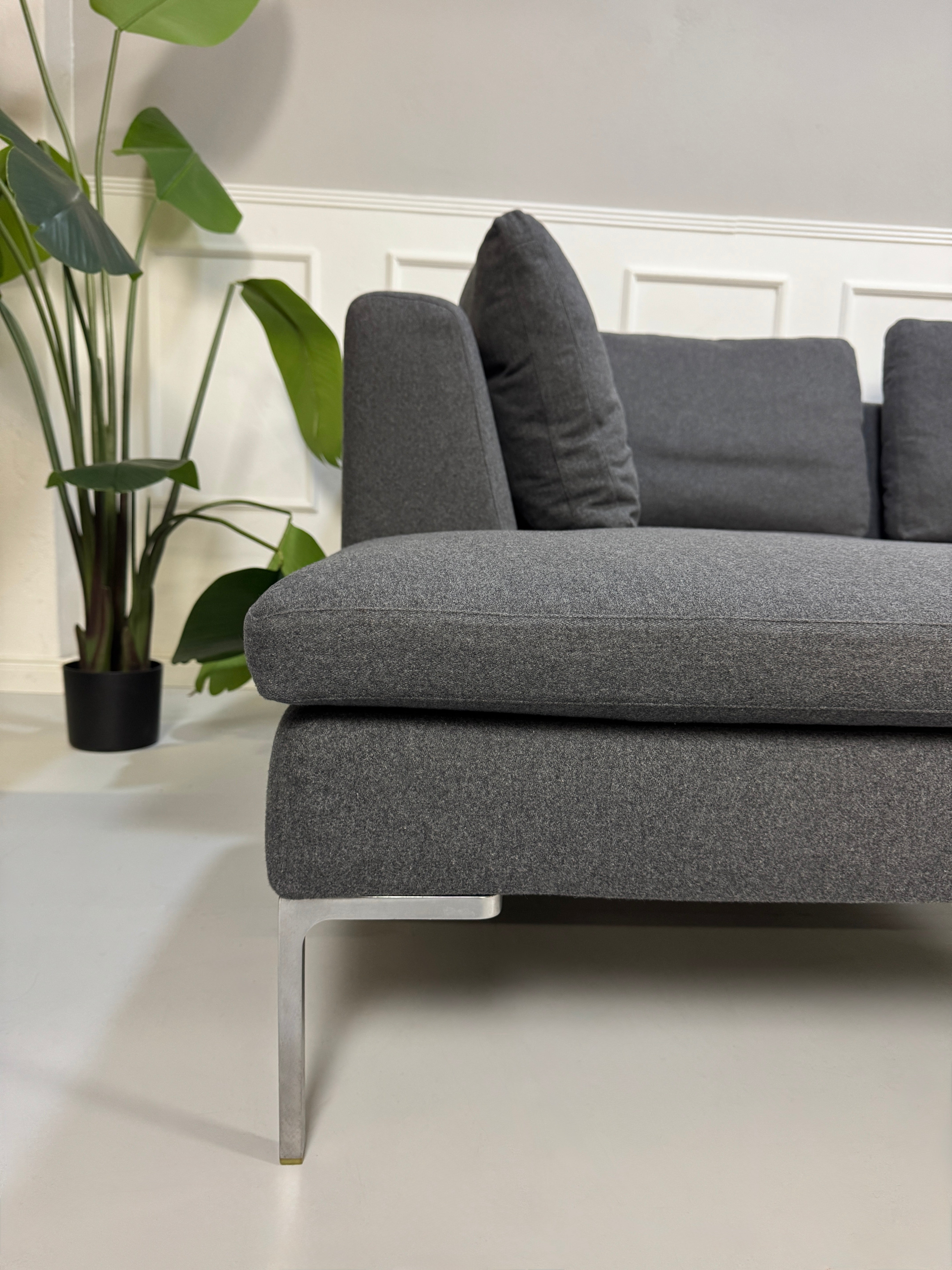 Gebrauchtes graues Stoffsofa  B&B Italia Modell Charles vor einer modernen Wand