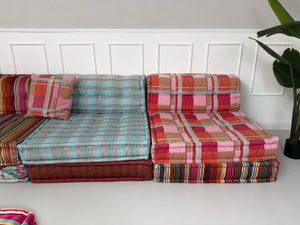 Gebrauchtes buntes Roche Bobois Mah Jong Designer Stoff Sofa vor einer Wand, stilvoll und modern eingerichtet.