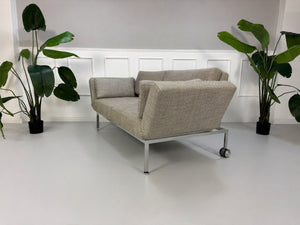 Gebrauchtes graues Brühl Roro Soft Designer Stoff Sofa vor einer Wand, stilvoll und modern eingerichtet.