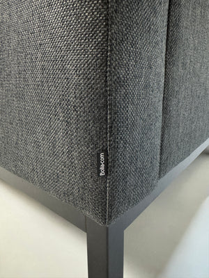 Gebrauchtes graues Stoffsofa Bolia Modell North vor einer modernen Wand.