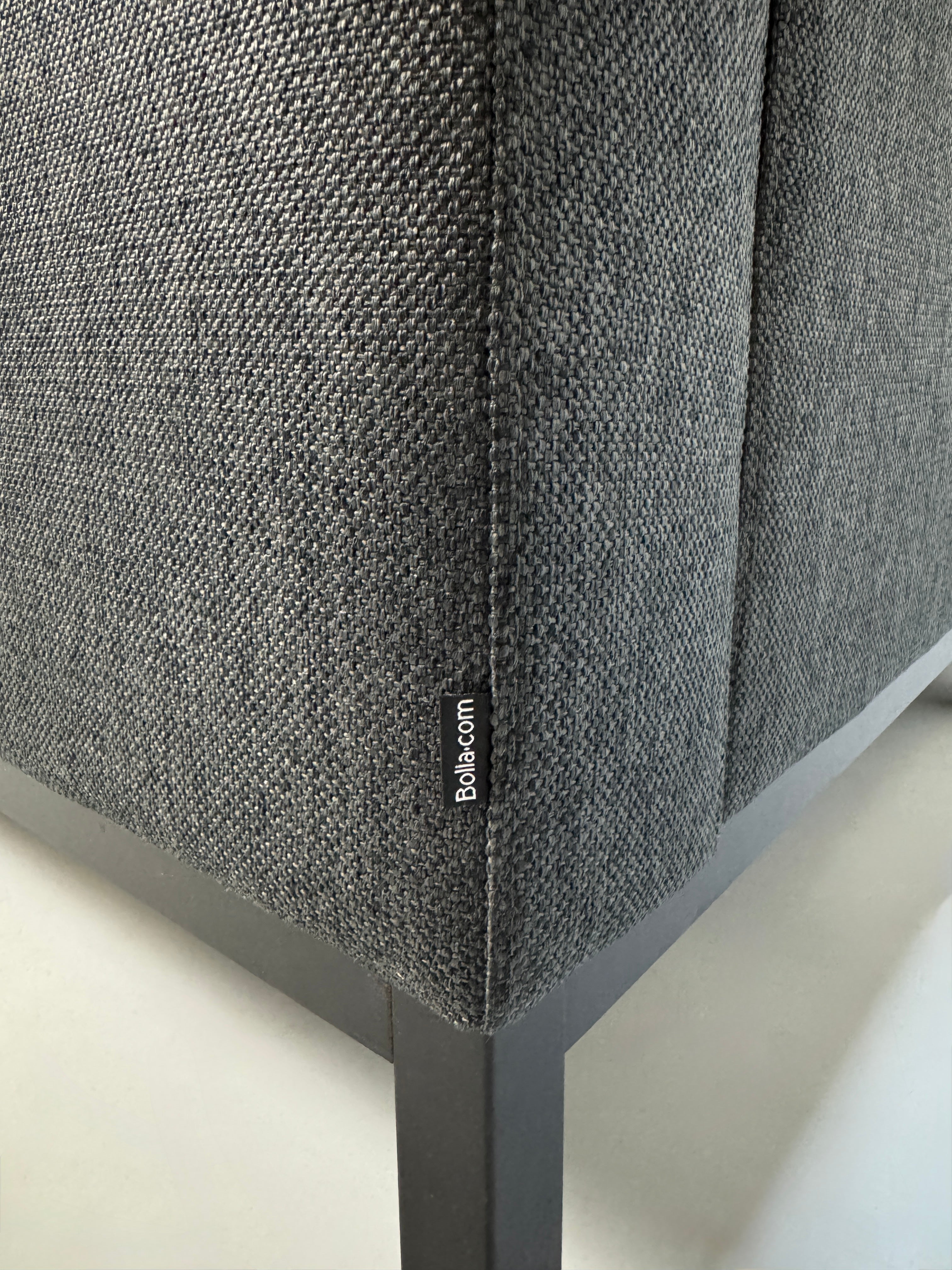 Gebrauchtes graues Stoffsofa Bolia Modell North vor einer modernen Wand.