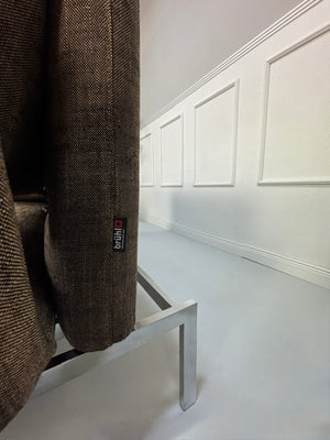 Gebrauchtes braunes Stoff Sofa Brühl Modell Roro vor einer modernen Wand.