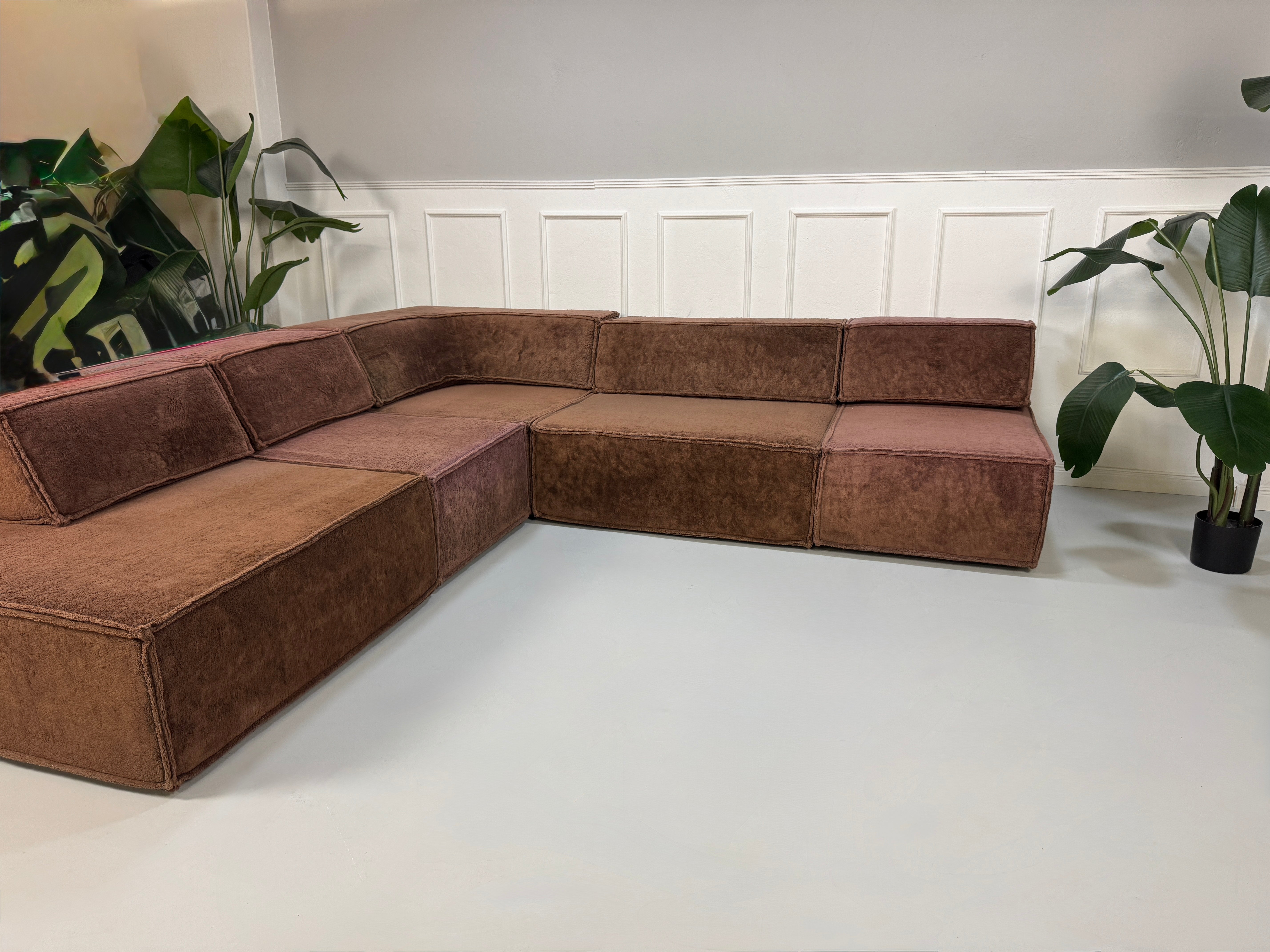 Gebrauchtes modulares braunes COR Trio Designer Stoff Sofa vor einer Wand, stilvoll und modern eingerichtet.