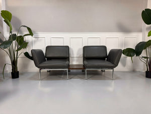 Gebrauchtes graues Brühl Roro Designer Leder Sofa mit Tisch vor einer Wand, stilvoll und modern eingerichtet.