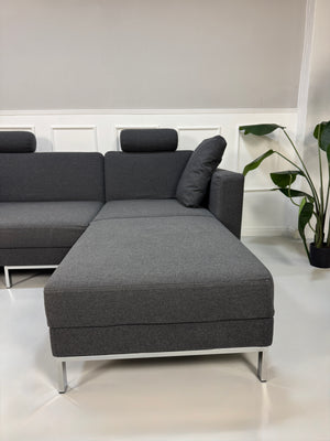 Gebrauchtes Brühl FourTwo Designer Stoff Sofa in der Farbe Grau vor einer Wand, stilvoll und modern eingerichtet.