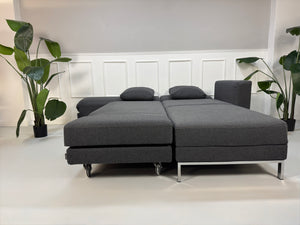 Gebrauchtes Brühl FourTwo Designer Stoff Sofa in der Farbe Grau vor einer Wand, stilvoll und modern eingerichtet.