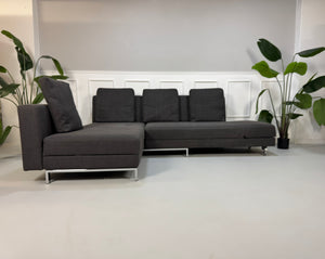 Gebrauchtes Brühl FourTwo Designer Stoff Sofa in der Farbe Grau vor einer Wand, stilvoll und modern eingerichtet.