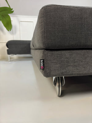Gebrauchtes Brühl FourTwo Designer Stoff Sofa in der Farbe Grau vor einer Wand, stilvoll und modern eingerichtet.