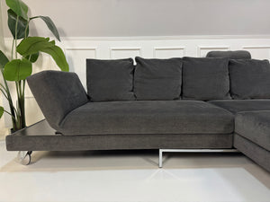 Gebrauchtes Brühl FourTwo Designer Stoff Sofa in der Farbe Grau vor einer Wand, stilvoll und modern eingerichtet.