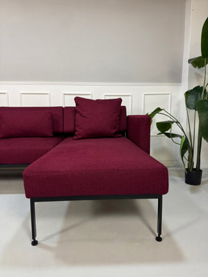 Gebrauchtes Brühl Roro Soft Designer Stoff Ecksofa in der Farbe Rot vor einer Wand, stilvoll und modern eingerichtet.