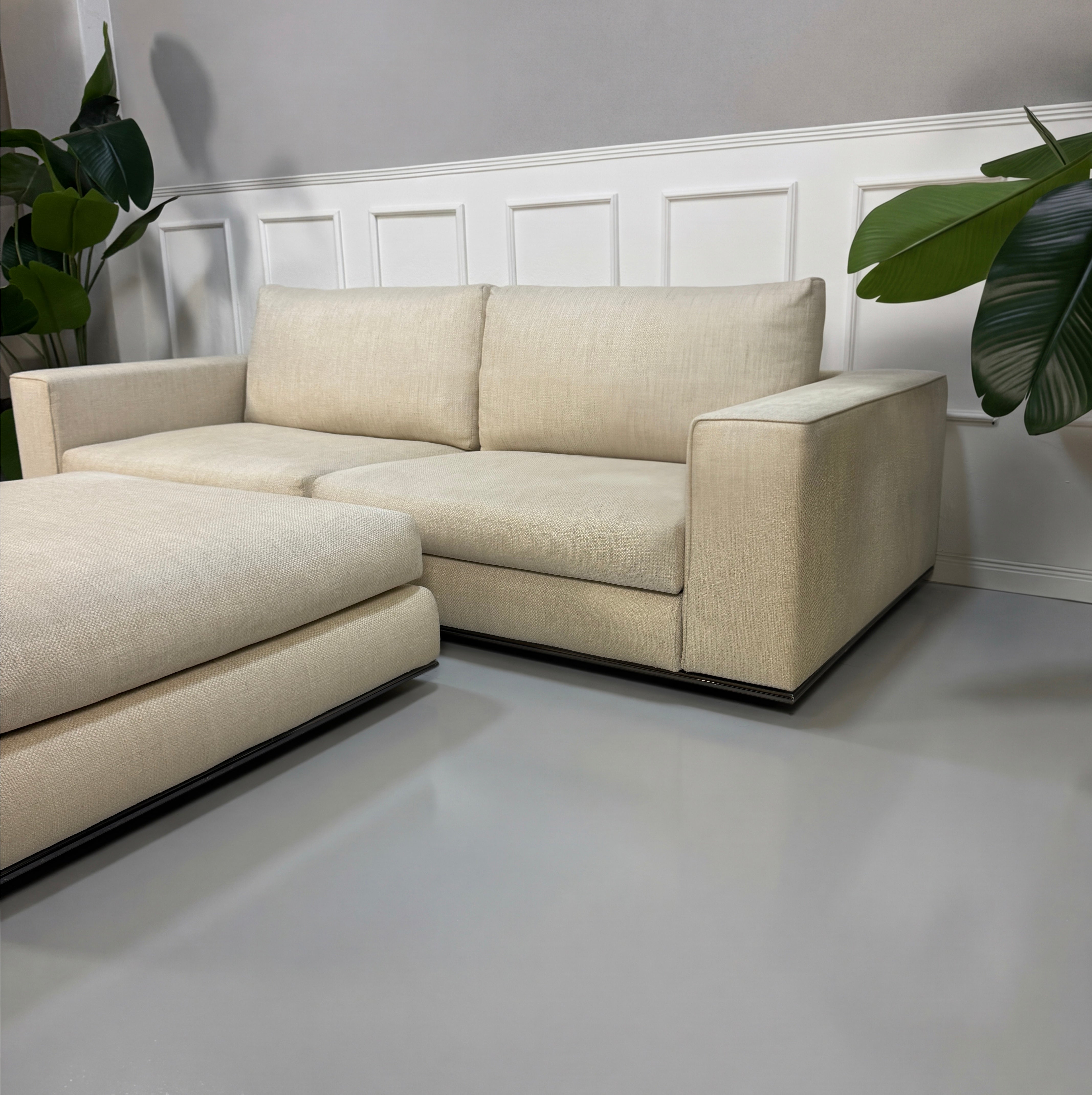 Gebrauchtes beiges Minotti Hamilton Designer Stoff Sofa mit Hocker vor einer Wand, stilvoll und modern eingerichtet.