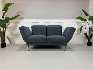 Gebrauchtes Brühl Moule Designer Stoff Sofa in der Farbe Blau vor einer Wand, stilvoll und modern eingerichtet.