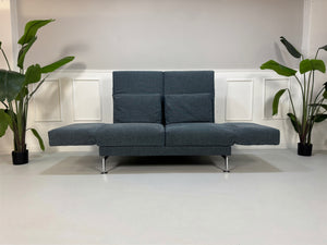 Gebrauchtes Brühl Moule Designer Stoff Sofa in der Farbe Blau vor einer Wand, stilvoll und modern eingerichtet.