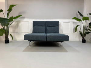 Gebrauchtes Brühl Moule Designer Stoff Sofa in der Farbe Blau vor einer Wand, stilvoll und modern eingerichtet.