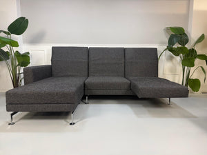 Gebrauchtes Brühl Moule Designer Stoff Sofa in der Farbe Grau vor einer Wand, stilvoll und modern eingerichtet.