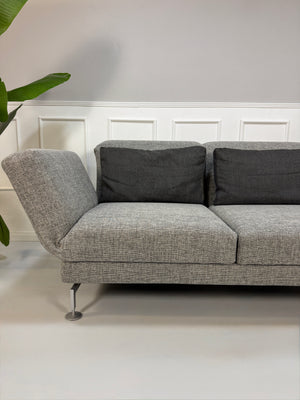 Gebrauchtes Brühl Moule Designer Stoff Sofa in der Farbe Grau vor einer Wand, stilvoll und modern eingerichtet.
