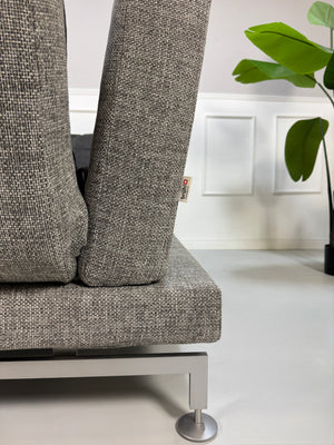 Gebrauchtes Brühl Moule Designer Stoff Sofa in der Farbe Grau vor einer Wand, stilvoll und modern eingerichtet.