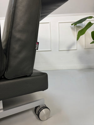 Gebrauchtes Brühl Moule Designer Leder Sofa in der Farbe Grau vor einer Wand, stilvoll und modern eingerichtet.