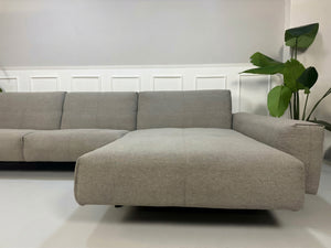 Gebrauchtes graues Rolf Benz 50 Designer Stoff Sofa vor einer Wand, stilvoll und modern eingerichtet.