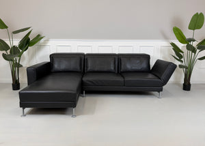 Refurbished Brühl Moule Designer Leder Sofa vor einer Wand, stilvoll und modern eingerichtet.