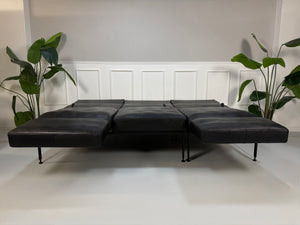 Gebrauchtes Brühl Roro Soft Designer Leder Sofa in der Farbe Schwarz vor einer Wand, stilvoll und modern eingerichtet.