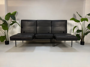 Gebrauchtes Brühl Roro Soft Designer Leder Sofa in der Farbe Schwarz vor einer Wand, stilvoll und modern eingerichtet.