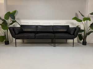 Gebrauchtes Brühl Roro Soft Designer Leder Sofa in der Farbe Schwarz vor einer Wand, stilvoll und modern eingerichtet.