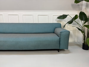Gebrauchtes Rolf Benz Grata Designer Stoff Sofa in der Farbe Blau vor einer Wand, stilvoll und modern eingerichtet.