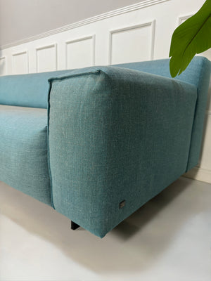Gebrauchtes Rolf Benz Grata Designer Stoff Sofa in der Farbe Blau vor einer Wand, stilvoll und modern eingerichtet.