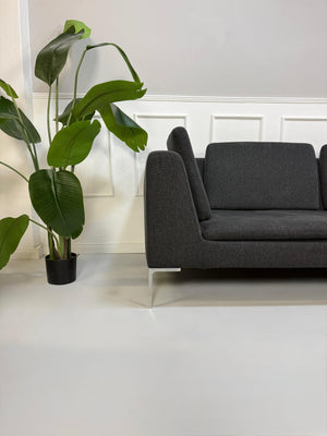 Refurbished graues B&B Italia Charles Designer Stoff Sofa vor einer Wand, stilvoll und modern eingerichtet.