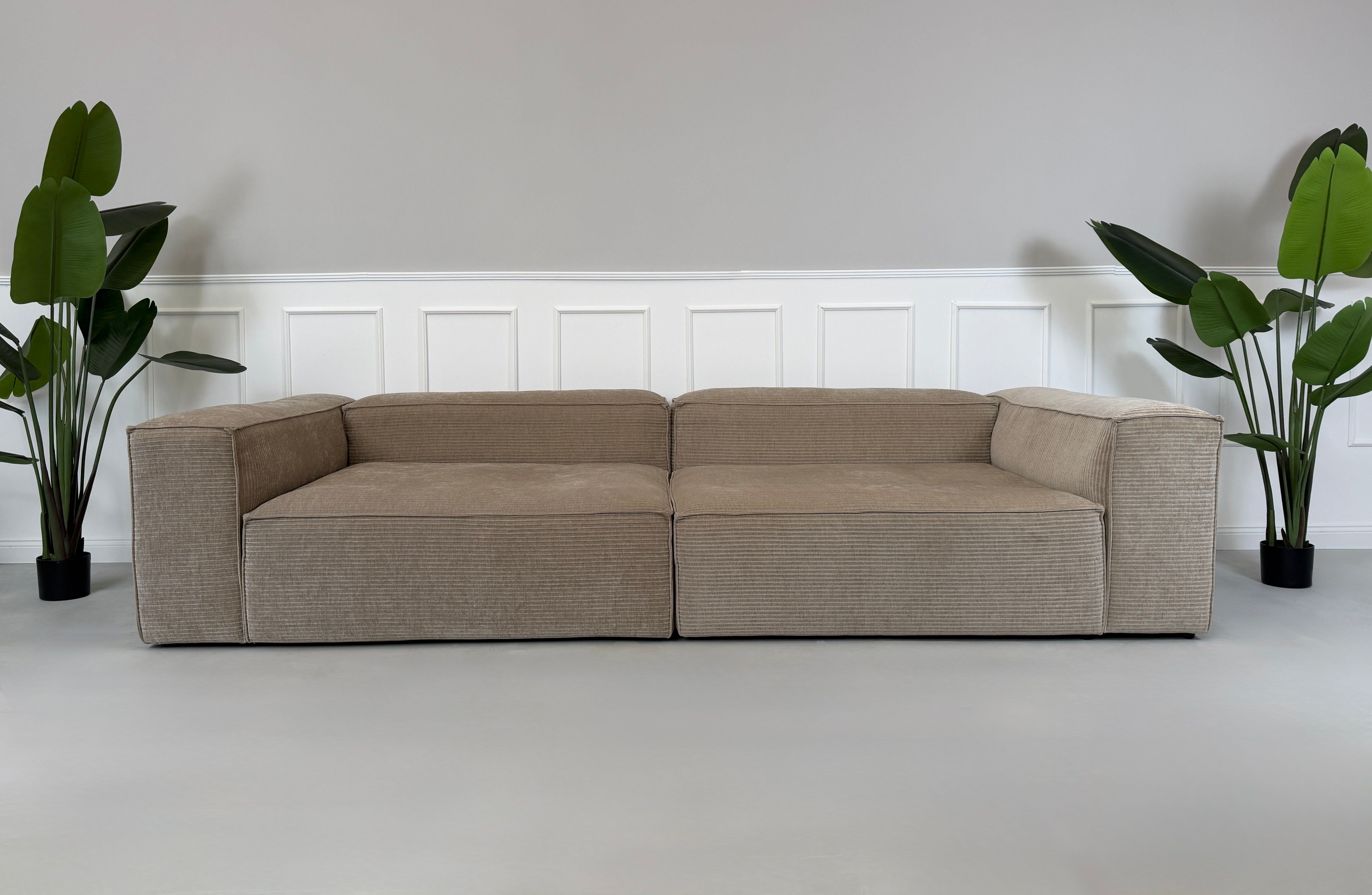 Erneuertes beiges Bolia Cosima Designer Cord Sofa vor einer Wand, stilvoll und modern eingerichtet.