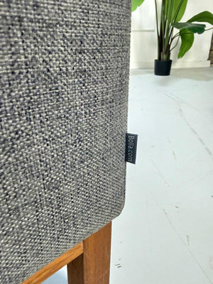 Gebrauchtes graues Bolia North Designer Stoff Sofa vor einer Wand, stilvoll und modern eingerichtet.