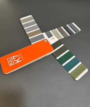 Gebrauchtes graues Brühl Moule Designer Leder Sofa vor einer Wand, stilvoll und modern eingerichtet.