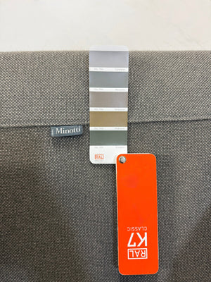 Erneuertes graues Minotti Sherman Designer Stoff Sofa vor einer Wand, stilvoll und modern eingerichtet.